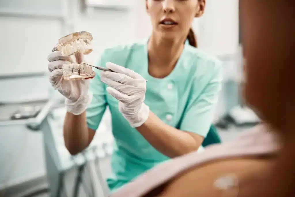 Dentist Examining Implant Prosthesis at Dental Clinic